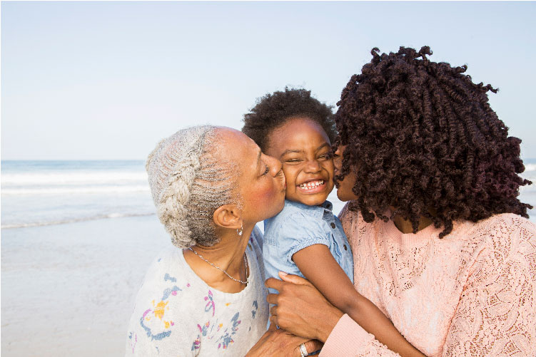 Grandmother, mother and child on a beach
