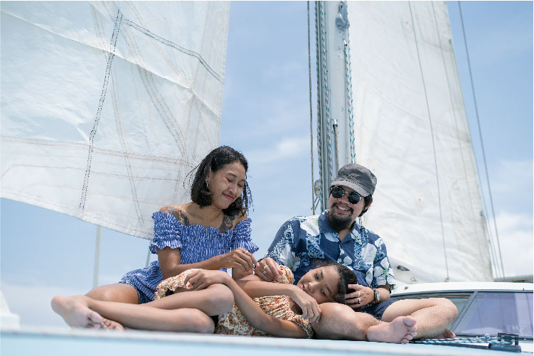 A couple and a girl on the deck of a sailboat